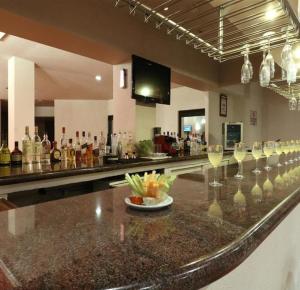 a bar with many wine glasses on a counter at Hotel Vilamiño in Aguascalientes