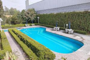 a swimming pool in front of a building at Hotel Vilamiño in Aguascalientes