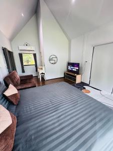 a room with a large bed and a flat screen tv at เขากิวเทอเรส @สิชล in Sichon