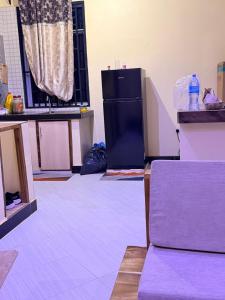 a kitchen with a black refrigerator in a room at Ways Rest in Msaranga