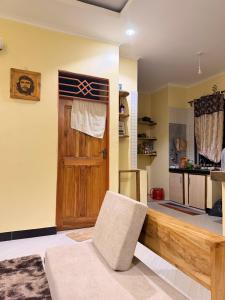a living room with a wooden door and a chair at Ways Rest in Msaranga