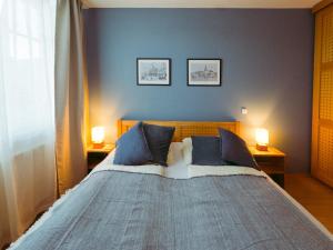a bedroom with a bed with two lamps on two tables at Ferienwohnung Ammersee in Andechs