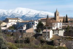 a town with a church and snowy mountains in the background at Casa Gratal (Siétamo, Huesca) in Siétamo