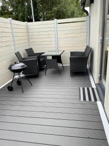 a patio with chairs and a table on a deck at Sosnowe Zacisze in Dębki