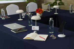 a blue table with a book and a bottle and glasses at Fiesta Inn Monterrey la Fe in Monterrey