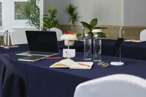 a blue table with a laptop computer and a book at Fiesta Inn Monterrey la Fe in Monterrey