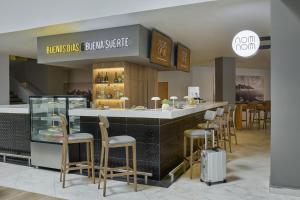 a restaurant with a counter with stools and a bar at Fiesta Inn Monterrey la Fe in Monterrey