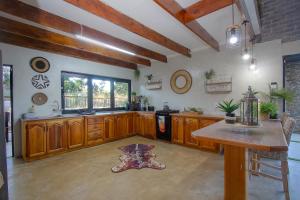 a large kitchen with wooden cabinets and a table at Edjami River View in Marloth Park