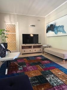 a living room with a television and a couch at Campbell comfort and convenience in Campbell