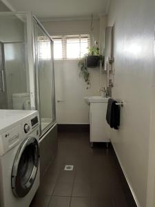 a bathroom with a washing machine and a sink at Campbell comfort and convenience in Campbell