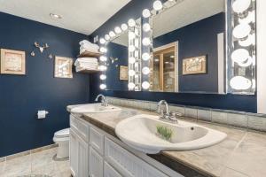 a bathroom with a sink and a large mirror at Riverfront Cottage - Steam Room & Pet Friendly in Bend