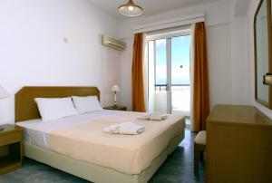 a bedroom with a bed with two towels on it at Castello Bianco Aparthotel in Platanes +81 photos