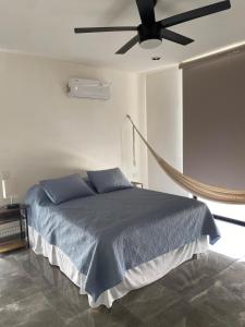 a bedroom with a bed with a ceiling fan at Otoch de Paz in Cholul +13 photos