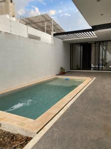 a swimming pool in the backyard of a house at Otoch de Paz in Cholul