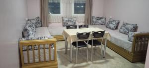 a room with a table and chairs and a bed at HOTEL AZOuR in Agadir