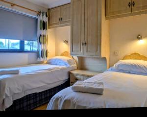 a bedroom with two beds and a window at Rossgier Inn in Lifford