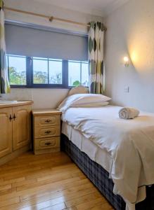 a small bedroom with a bed and a window at Rossgier Inn in Lifford +13 photos