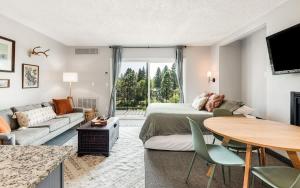 a living room with a bed and a couch and a table at Riverview Pet Friendly Condo in Downtown Bend in Bend