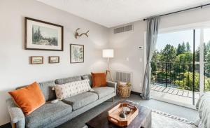 a living room with a couch and a large window at Riverview Pet Friendly Condo in Downtown Bend in Bend