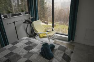 a bedroom with a bed and a chair and a window at Chatka Bratka in Kletno