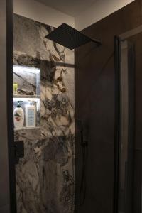 a bathroom with a shower with a stone wall at Chatka Bratka in Kletno +11 photos