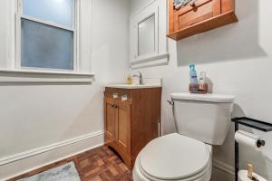 a bathroom with a toilet and a sink and a window at 8 Mi to Micron Technology! Walkable Phoenix Gem in Phoenix