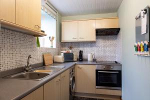 a small kitchen with a sink and a stove at Hallbank Hideout in Amble