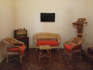 a living room with two chairs and a tv at Posada Las Piedras in Tilcara