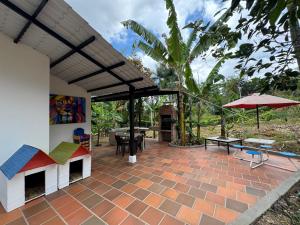 a patio with a dog house and an umbrella at Finca Sol y Luna in San Gil