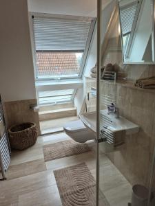 a bathroom with a toilet and a sink and a window at Solarhaus Guxhagen in Guxhagen