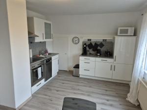 a kitchen with white cabinets and a stove top oven at Solarhaus Guxhagen in Guxhagen