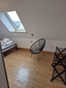 a room with a chair and a bed and a window at Solarhaus Guxhagen in Guxhagen +2 photos