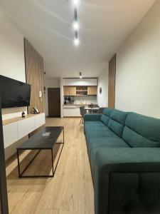 a living room with a green couch and a table at RIVER LuX in Veliko Gradište