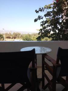 a table and a chair on a balcony with a view at Castello Azzurro in Agia Anna Naxos
