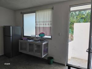 a kitchen with a sink and a refrigerator and a window at Nómadas in San Luis