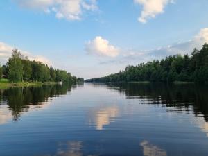 a river with trees on the sides of it at The River House & Riverside Sauna in Kokkola
