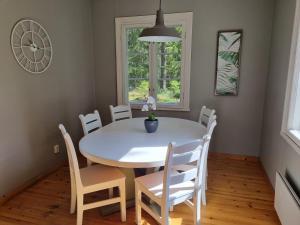 a dining room with a white table and chairs at The River House & Riverside Sauna in Kokkola