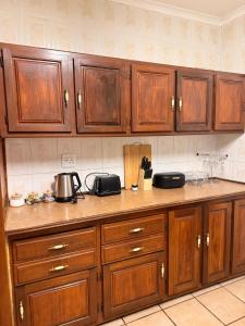 a kitchen with wooden cabinets and a counter top at Soulfenda guest house in Graskop