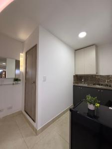 a kitchen with a large white wall and a wooden door at Apartaestudio grupal privado dentro de hotel in Medellín