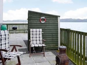 a green shed with two chairs and a wreath on it at Seaview in Garlieston