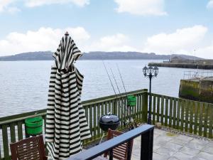 a umbrella sitting on a deck next to the water at Seaview in Garlieston +15 photos