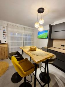 a dining room with a table and a yellow chair at Boho Studio Enjoy in Neoi Epivates +16 photos