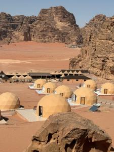 a group of domes in a desert with mountains at Mangle luxury rum camp in Disah