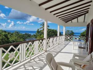 a balcony with chairs and a view of the ocean at Chrysalide in Baillif