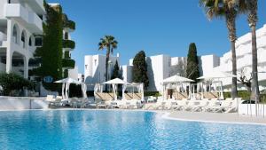 a pool with chairs and umbrellas in front of a building at BLUESEA Ses Cases d'Or in Cala d´Or +29 photos