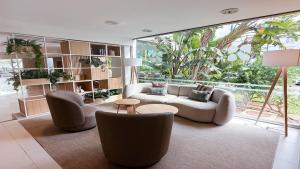 a living room with two couches and a large window at BLUESEA Ses Cases d'Or in Cala d´Or