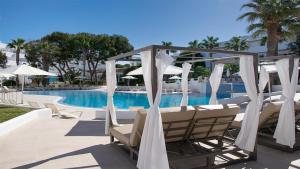a group of chairs and umbrellas next to a pool at BLUESEA Es Bolero in Cala d´Or +29 photos
