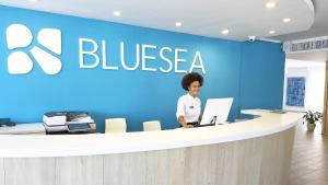 a woman standing at the counter of a blueza office at BLUESEA Costa Verde in El Arenal
