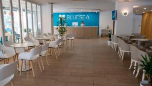a dining room with tables and white chairs at BLUESEA Costa Verde in El Arenal