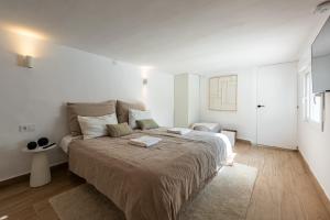 a bedroom with a large bed in a white room at Cozy Villa With Pool In Marbella Nueva Andalucia in Marbella +16 photos